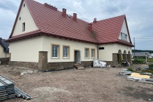 żółty dom ludowy z czerwonym dachem w trakcie modernizacji