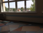 sala lekcyjna SP1 Dobczyce nowa wykładzina na niej ławki w tle okna