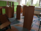 sala lekcyjna SP1 Dobczyce nowa wykładzina na niej ławki w tle okna
