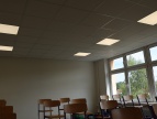 sala lekcyjna SP1 Dobczyce sufit biały podwieszany, w tle okna na dole krzesła na ławkach