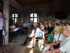 zamkowa sala w niej widownia spotkania poetyckiego oraz prowadzący wydarzenie