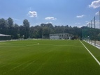 zielona murawa boiska otoczona drzewami