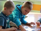 dwójka małych chłopców siedząca przy stoliku