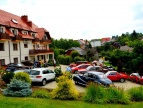budynek hotelu, a przed nim stoją samochody na parkingu 
