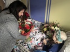wręczenie bukietów kwiatów starszej kobiecie 